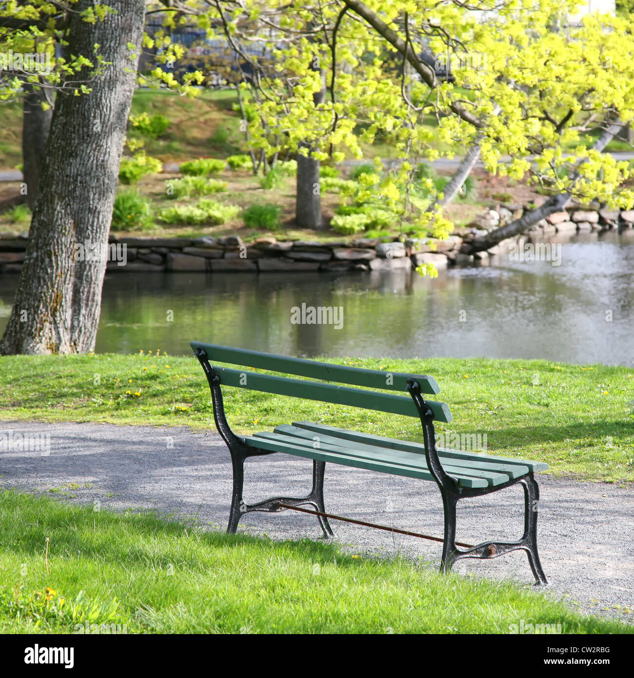 Legno vuota una panchina nel parco che si affaccia su di un lago o stagno in Halifax Giardini Pubblici, Halifax, Nova Scotia, Canada. Foto Stock