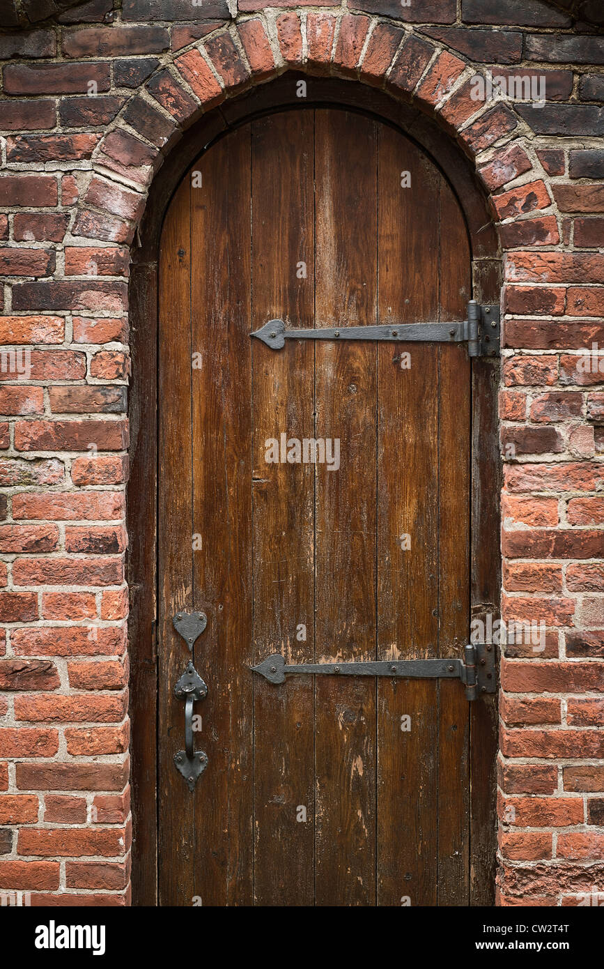 Rustico arcuata porta di legno e walled garden. Foto Stock