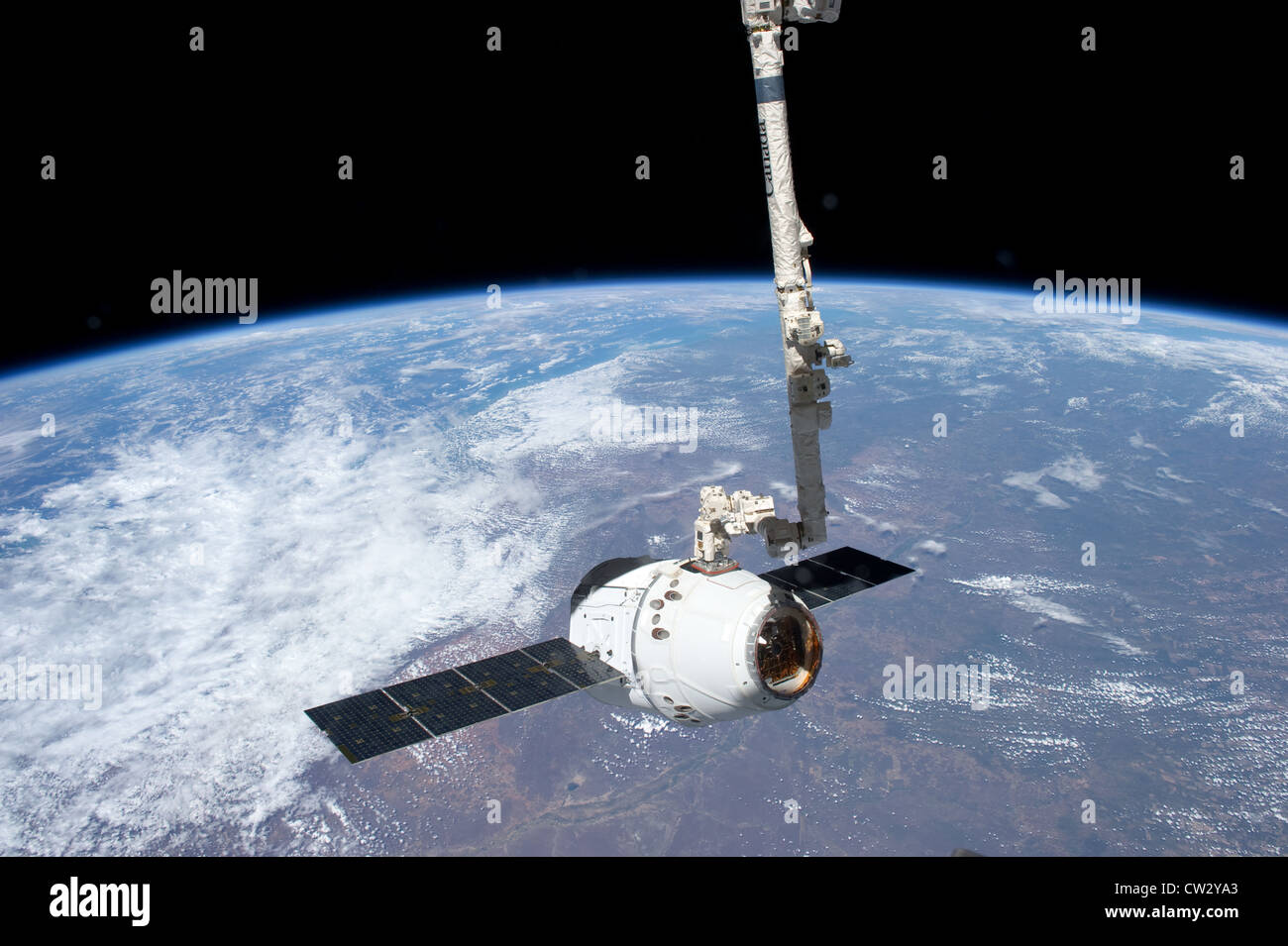 SpaceX Dragon commerciale cargo craft agganci dal Canadarm2 braccio robotico presso la Stazione Spaziale Internazionale vista terra Foto Stock