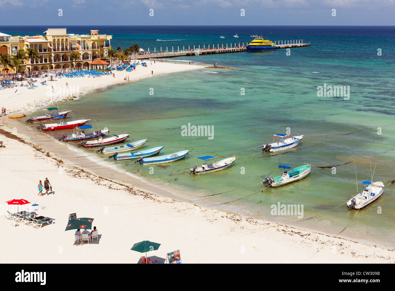 Vista della spiaggia con barche da pesca, hotel e pier a Playa del Carmen Foto Stock