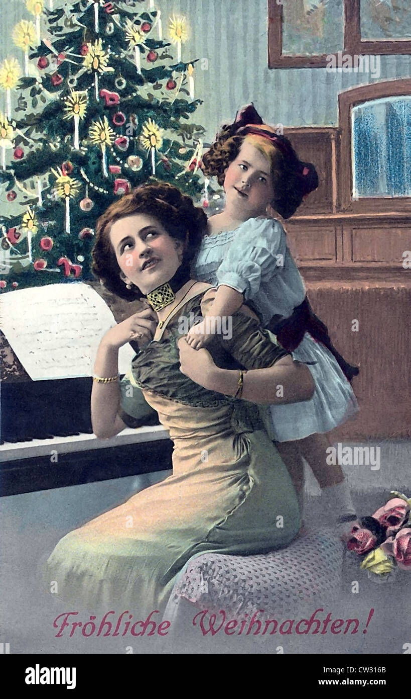 Donna seduta con il bambino nella parte anteriore dell'albero di Natale Foto Stock