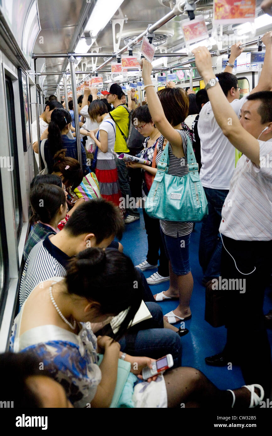 All'interno del tubo della metropolitana treno vano del carrello con il cinese pendolari / passeggeri pendolari. Sistema di metropolitana. Pechino, Cina Foto Stock