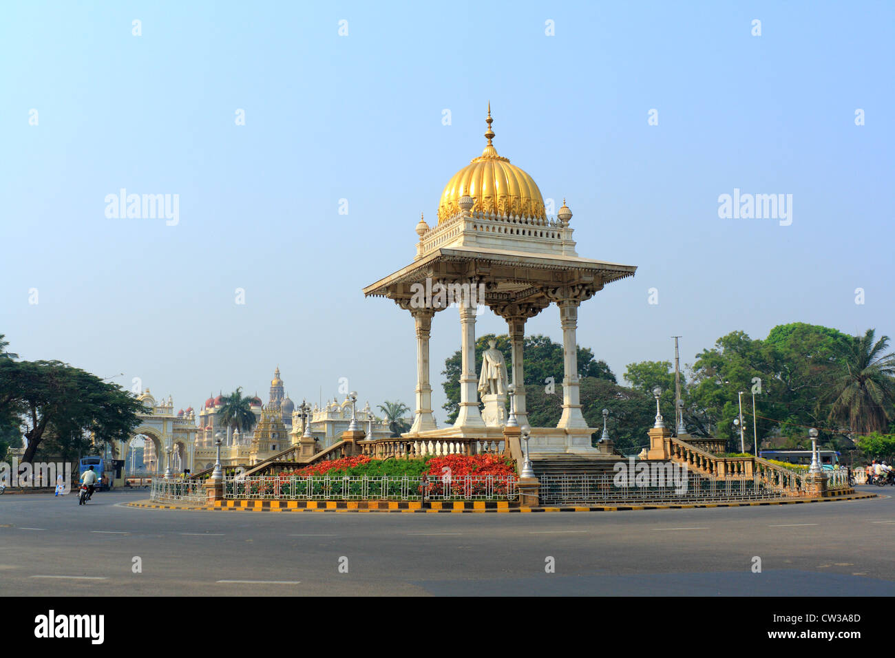 Una statua del Maharaja Krishnaraja Wodeyar al centro di una rotatoria a Mysore, con Mysore Palace in background. Foto Stock