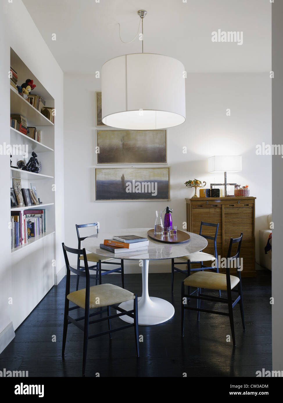 Interni moderni, di un soggiorno in un appartamento italiano con una cena Sarinen tavolo e Super leggera sedie Foto Stock