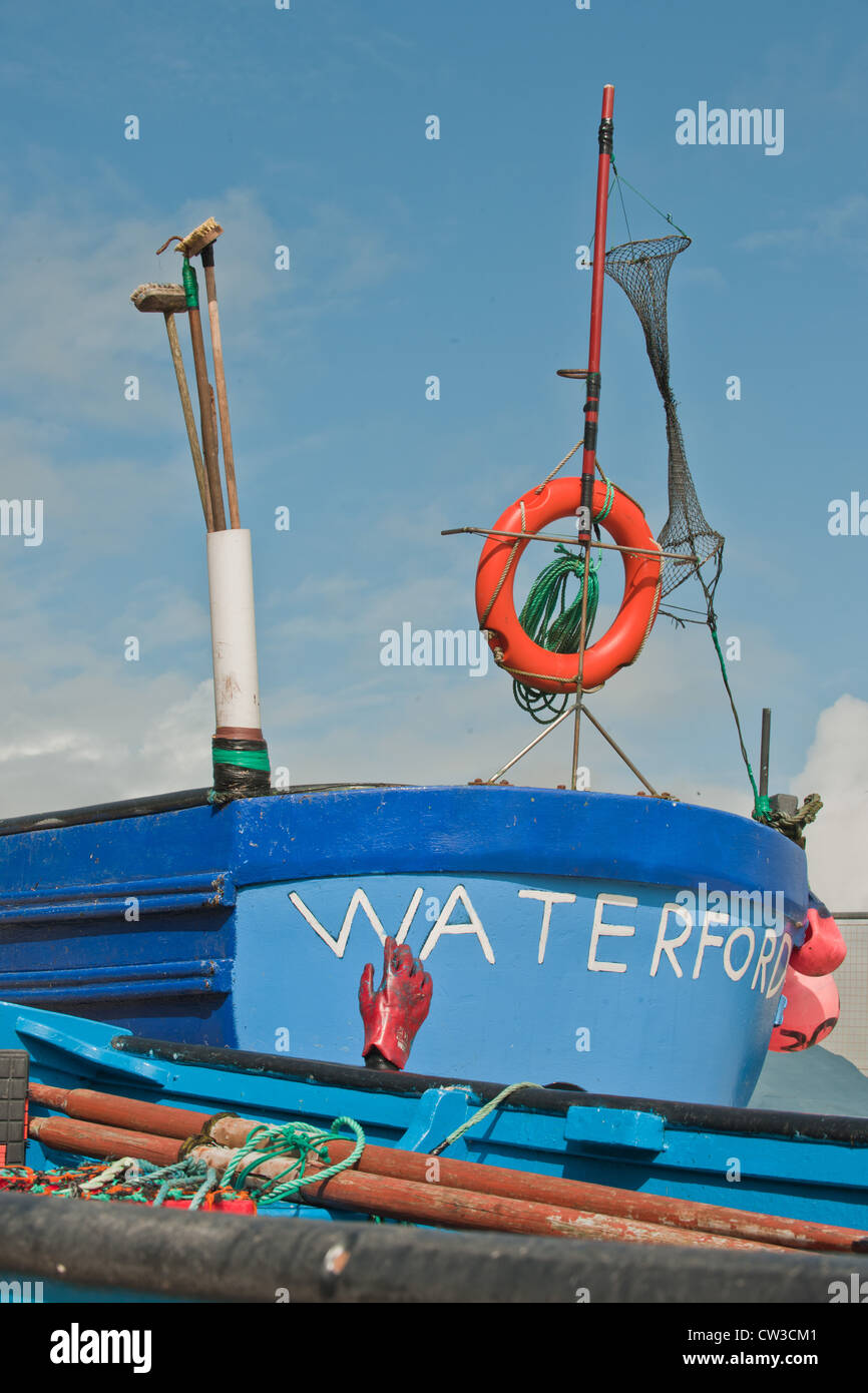 Un dipinto luminosamente barca da pesca trovati sul porto di Ardmore in Irlanda. Foto Stock