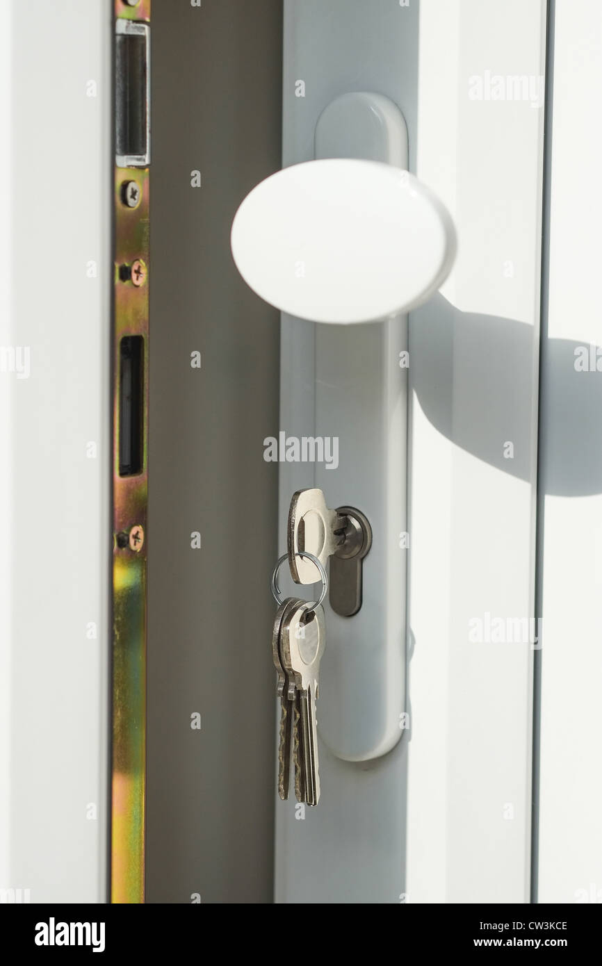 Close-up shot aperto di UPVC bianco doppi vetri porta con chiavi nella serratura - luminoso con un'ombra. Foto Stock