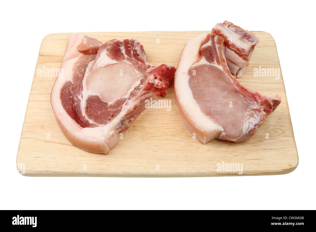 Due materie costolette di maiale su una tavola di legno preparazione alimentare board isolata contro bianco Foto Stock