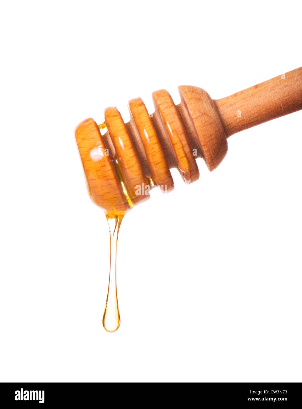 Il miele il gocciolamento da un bilanciere di legno isolato su sfondo bianco Foto Stock