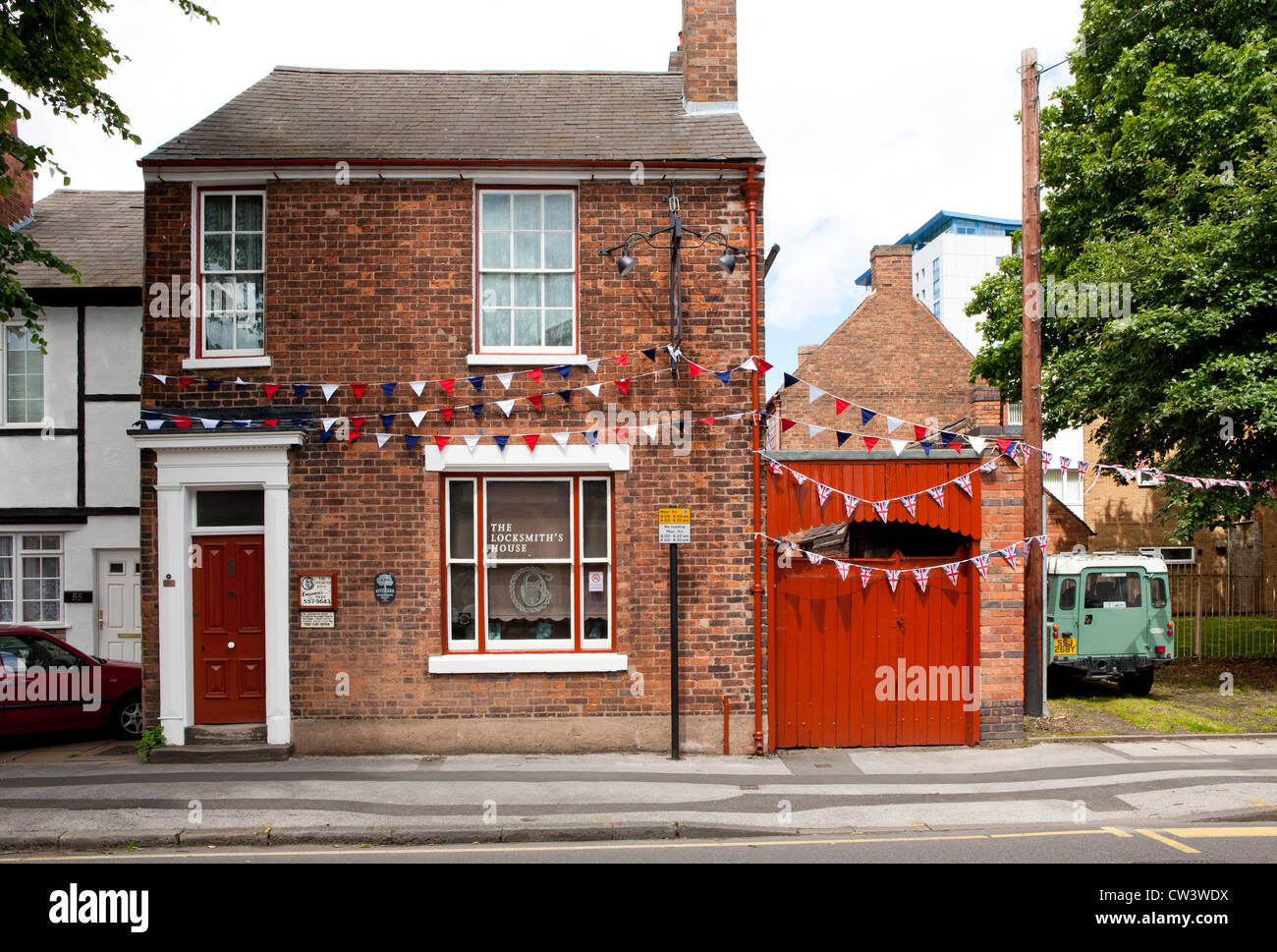 Una casa inglese è decorata con colori britannica, bandiere e bunting nella celebrazione del passaggio della torcia Olimpica. Foto Stock