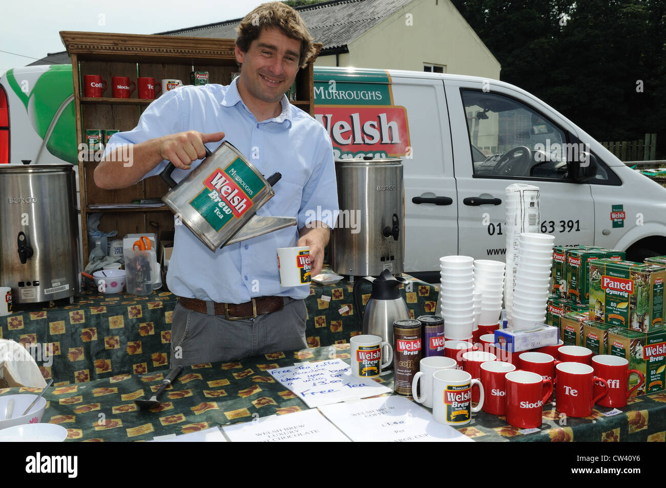 Stallholder versando una tazza di Welsh Brew Tea Cardigan Riverside Food Festival Ceredigion nel Galles Cymru REGNO UNITO GB Foto Stock