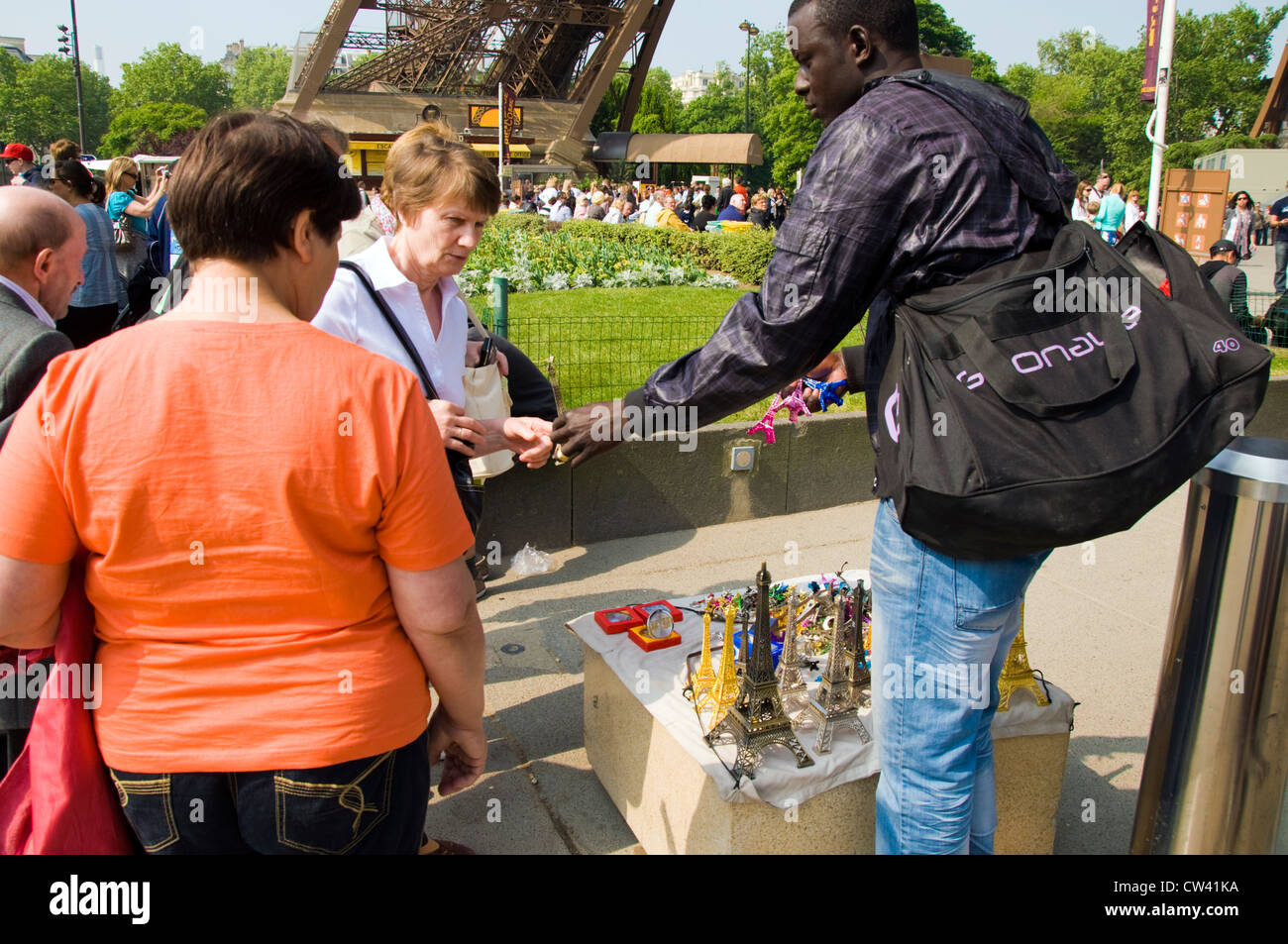 Tourist acquista un modello della Torre Eiffel da un venditore ambulante presso la Torre Eiffel a Parigi Foto Stock
