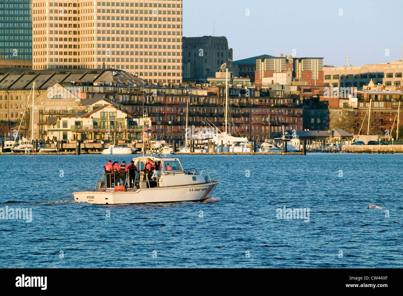 Stati Uniti Guardia costiera pattuglie della nave al porto di Boston e la skyline di Boston da terroristi sunrise come visto da South Boston Massachusetts Foto Stock