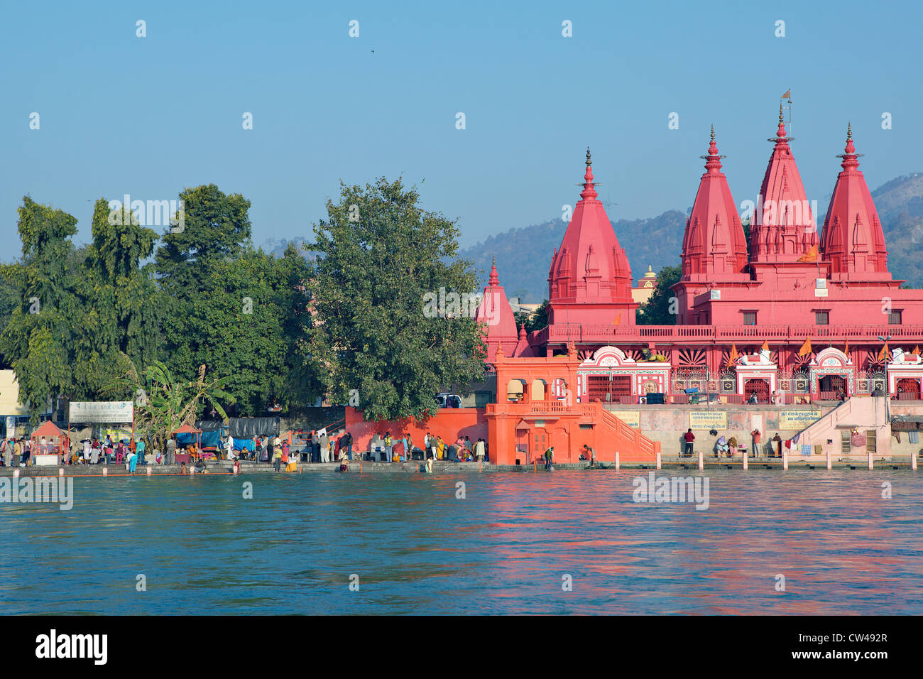 Pellegrini la balneazione nel fiume Gange accanto a un tempio indù. Kumbh Mela Festival 2010, Haridwar, India. Foto Stock