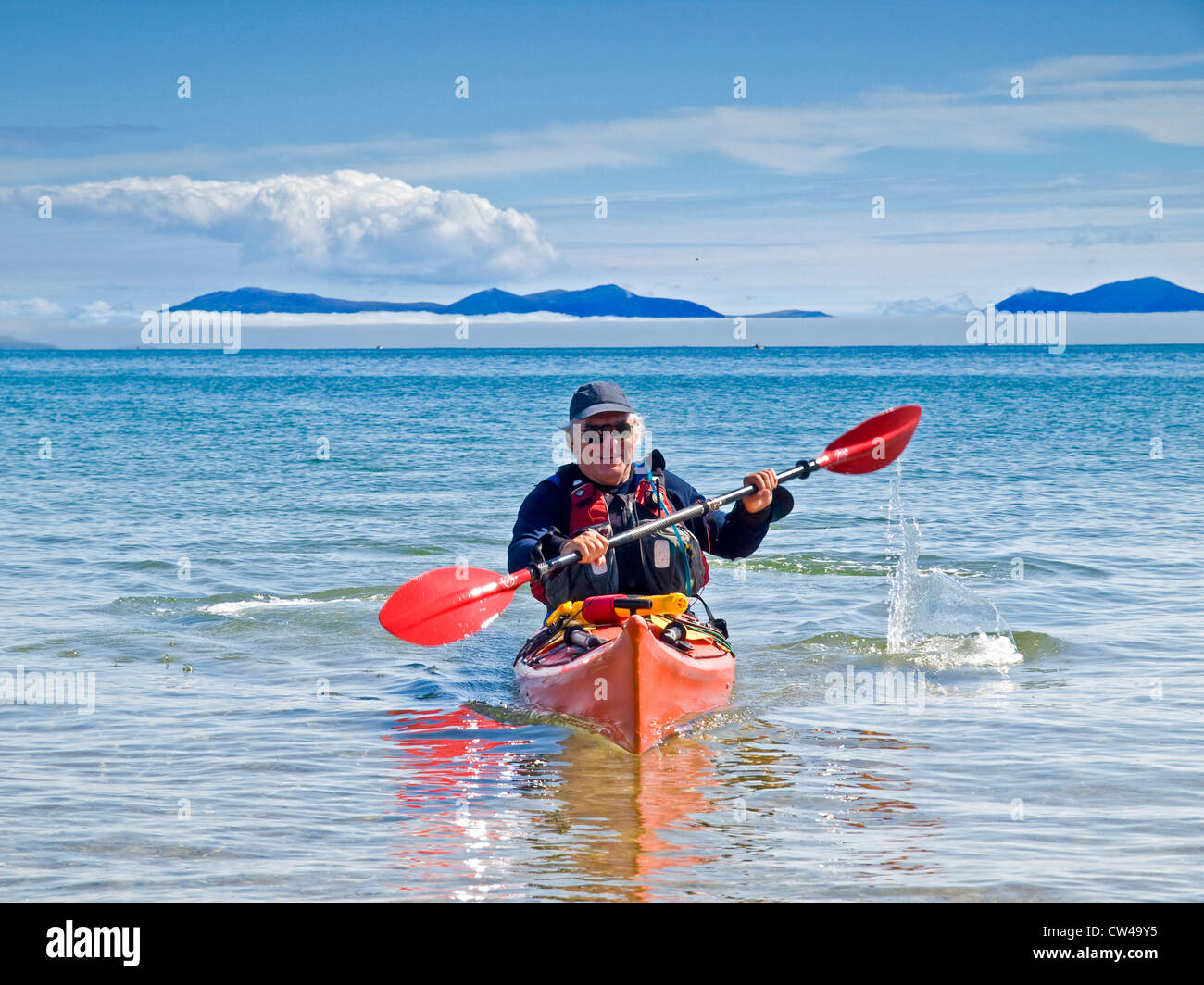 Un uomo in pensione il kayak da mare su Anglesey, Galles Foto Stock