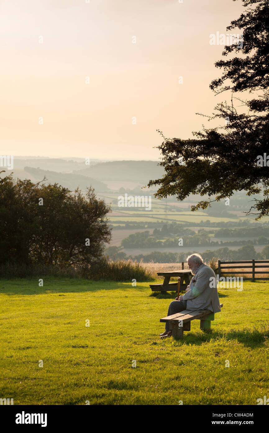 Persone anziane signore seduto sul banco in paese parco godendo il sole serale Foto Stock