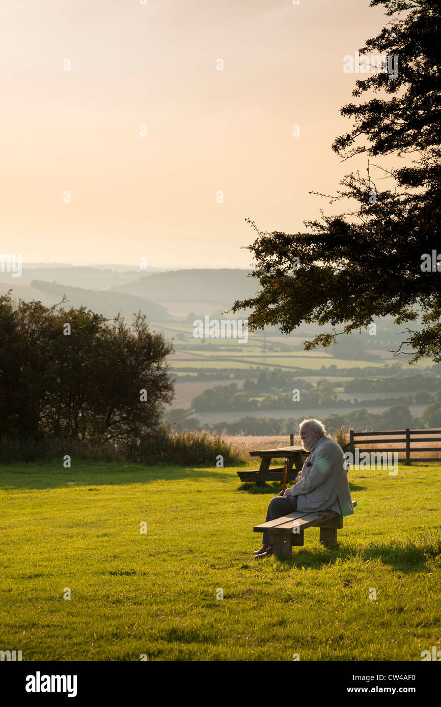 Persone anziane signore seduto sul banco in paese parco godendo il sole serale Foto Stock