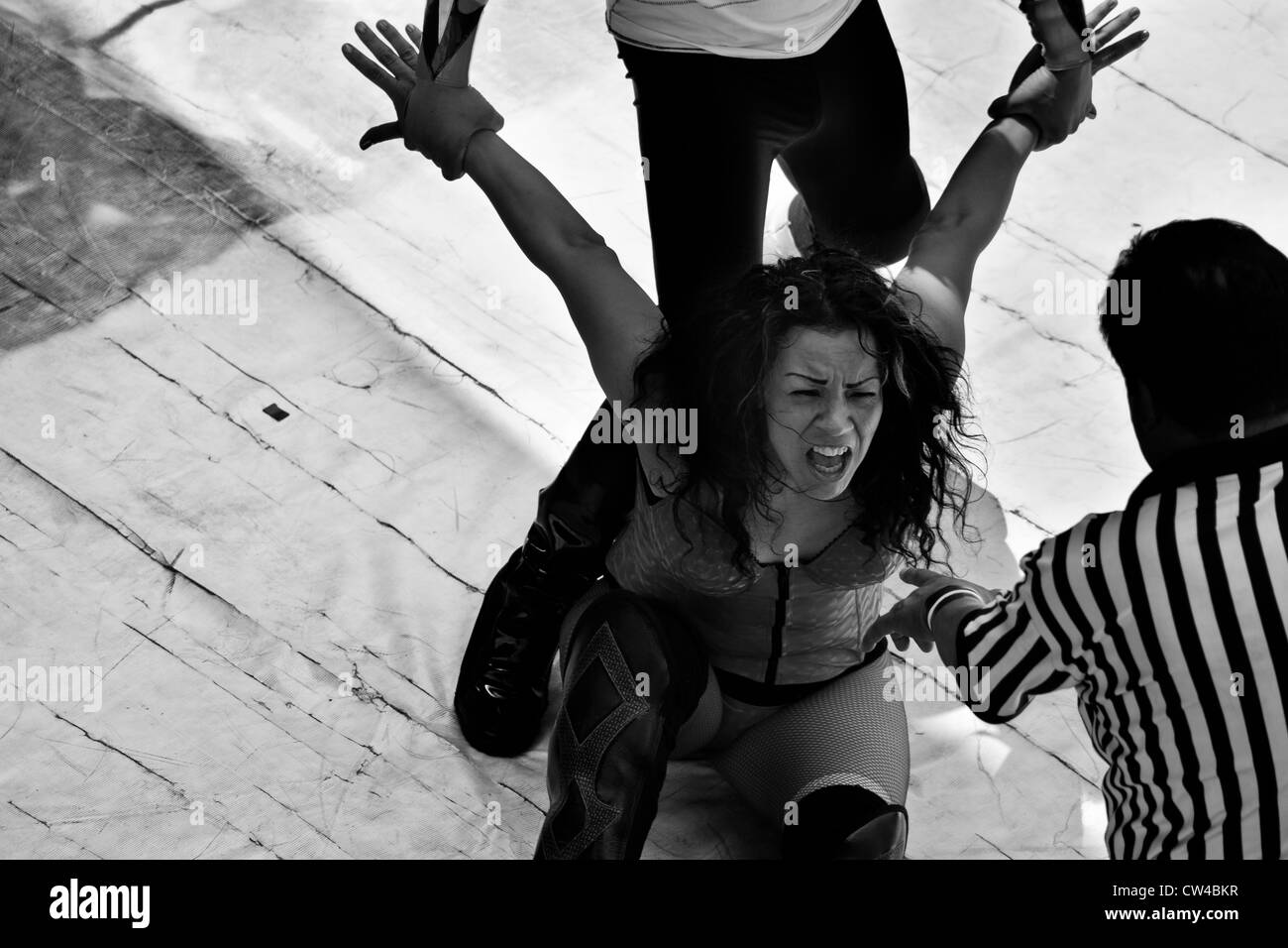 Una femmina di lucha libre wrestler sahori visto bloccato in una dolorosa attesa durante una lotta a livello locale arena di Città del Messico. Foto Stock