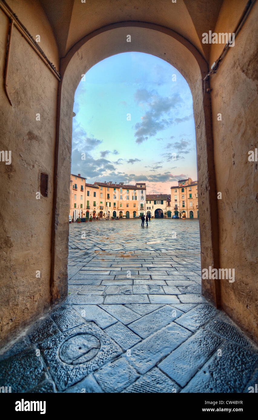 Serata in uno degli ingressi alla Piazza dell'Anfiteatro nella città toscana di Lucca, Italia Foto Stock