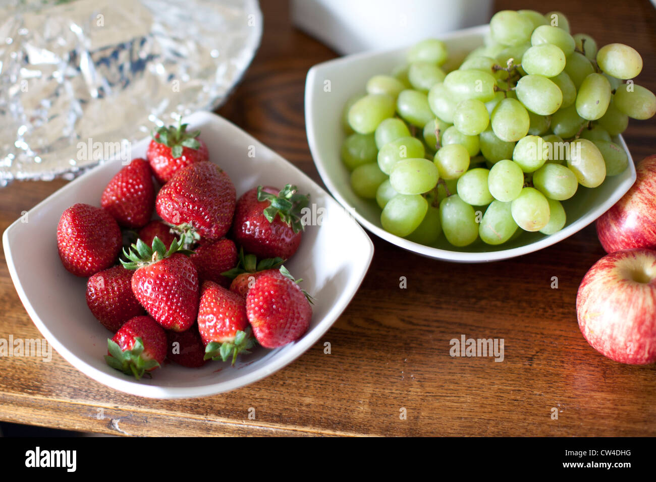 Coppe di frutta, fragole, uva, mele Foto Stock