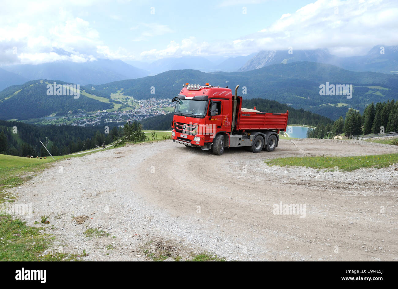 Mercedes actros quattro ruote di azionamento carrello ribaltabile guida su una montagna ghiaiose via per fornire materiale per una stazione di sci. Foto Stock