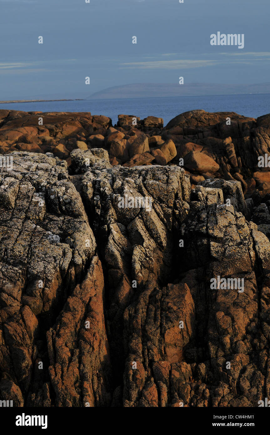 Costiera di basalto ignea formazioni rocciose off l'Atlantico occidentale costa dell'Irlanda, Carraroe, Conamara, nella contea di Galway. Foto Stock