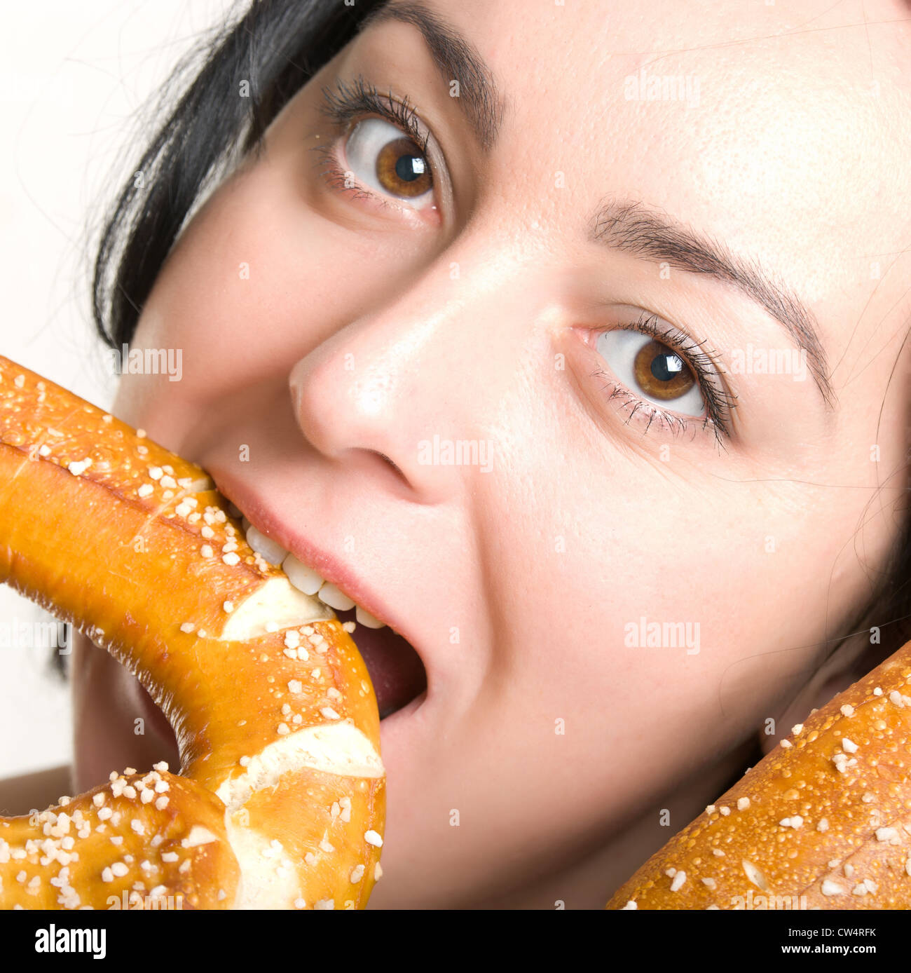 Una donna mangia un tradizionale tedesco bagel - Bretzel. Foto Stock