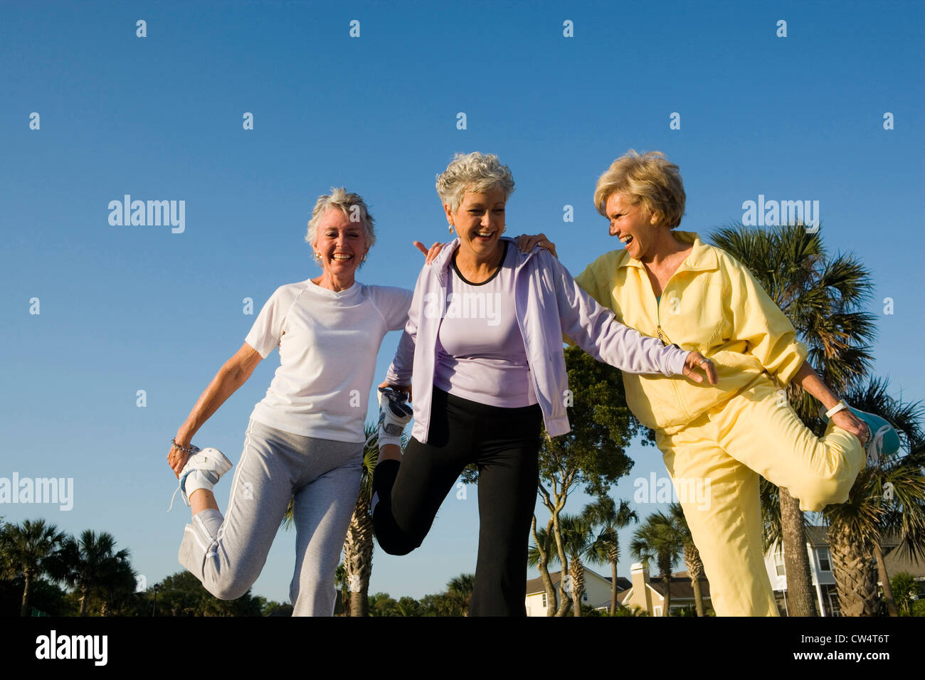 Le donne anziane di ridere mentre in equilibrio su una gamba Foto Stock