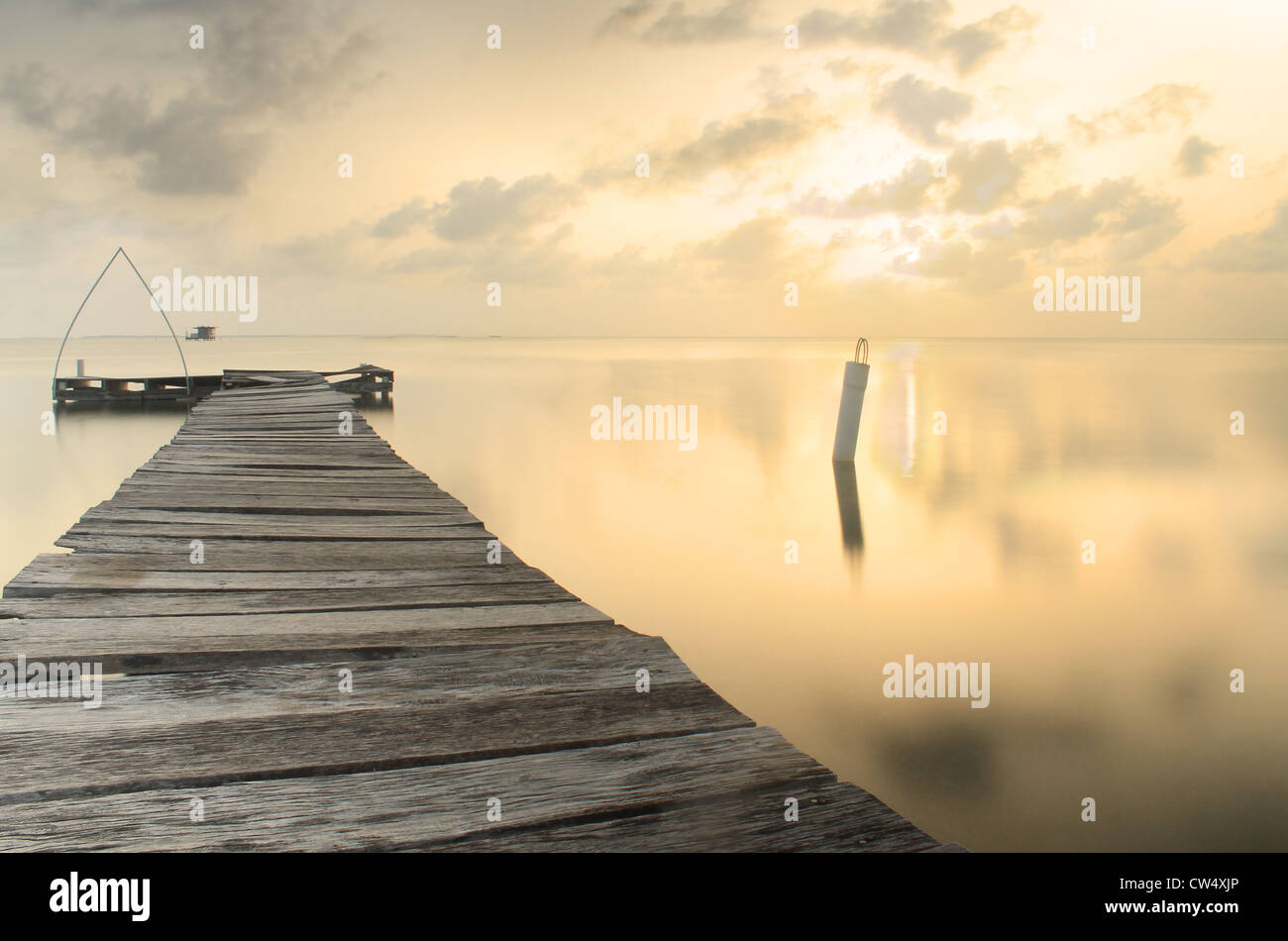 Tramonto a caldo con il vecchio dock sul il Caribe con chiave Caulker, Belize Foto Stock