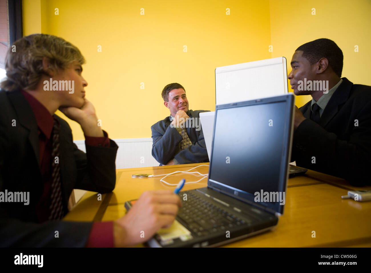 Uomini d'affari in pieno suit conversare in un ufficio Foto Stock