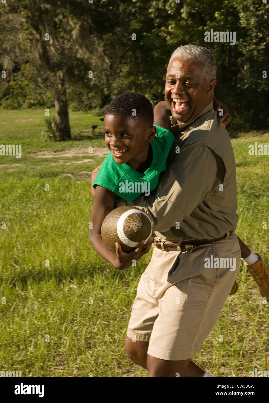Padre e figlio tenendo il calcio al bosco Foto Stock