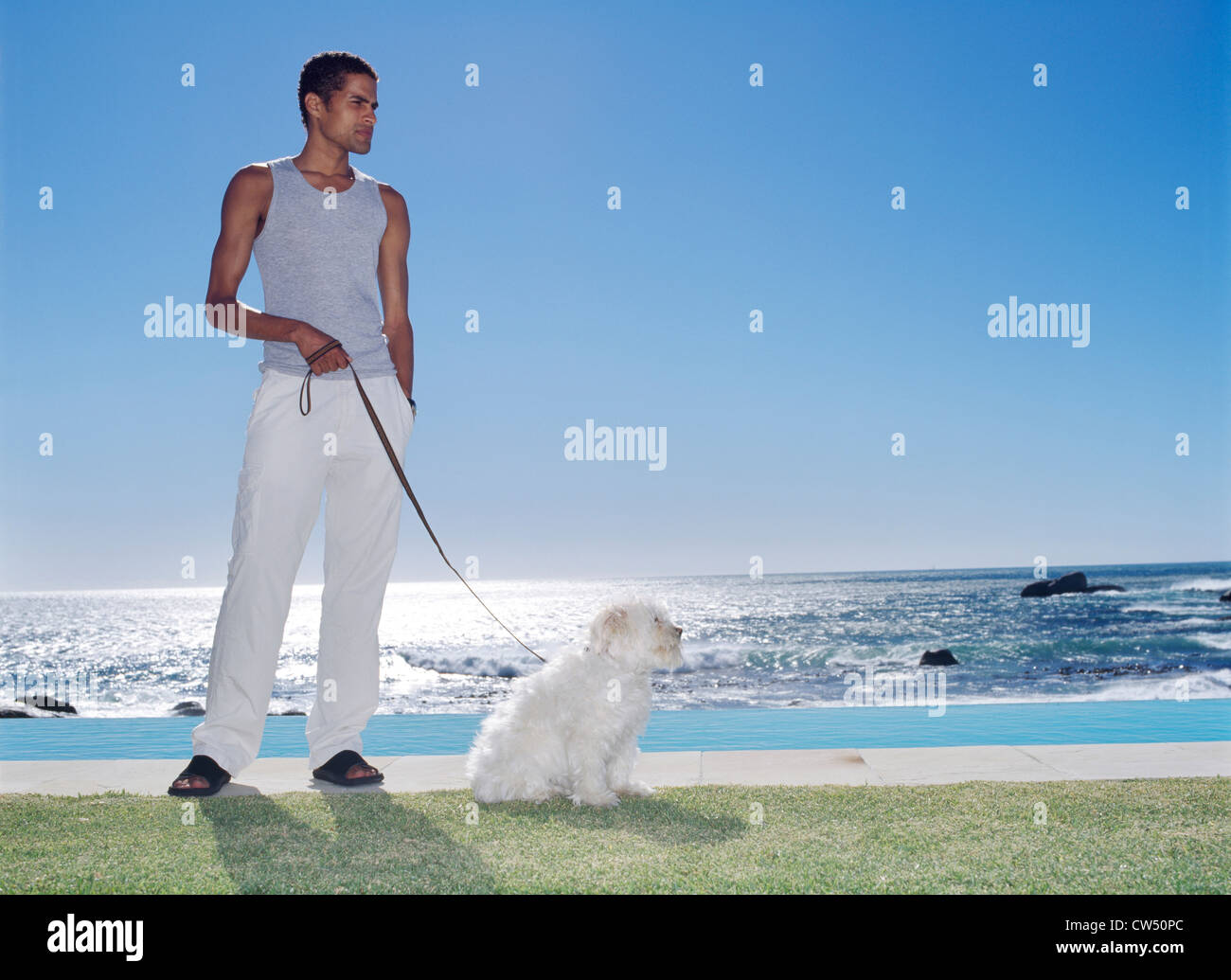 Giovane uomo in possesso di un cane al guinzaglio Foto Stock