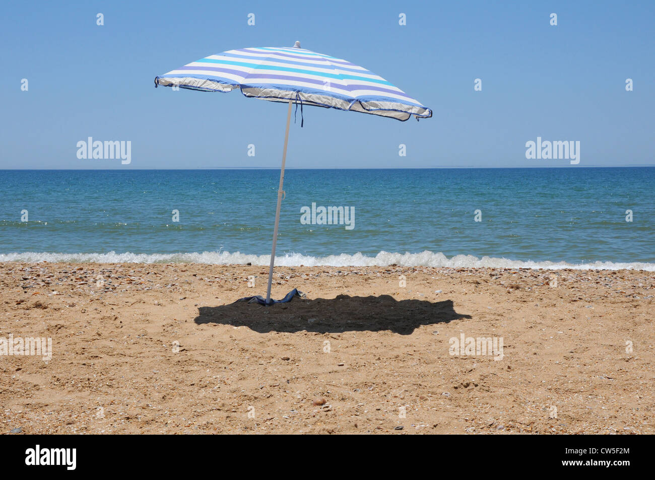 Blu e bianco ombrellone sulla spiaggia, con ombre, mare Punta Umbria, Costa  de la Luz Huelva, Spagna Foto stock - Alamy
