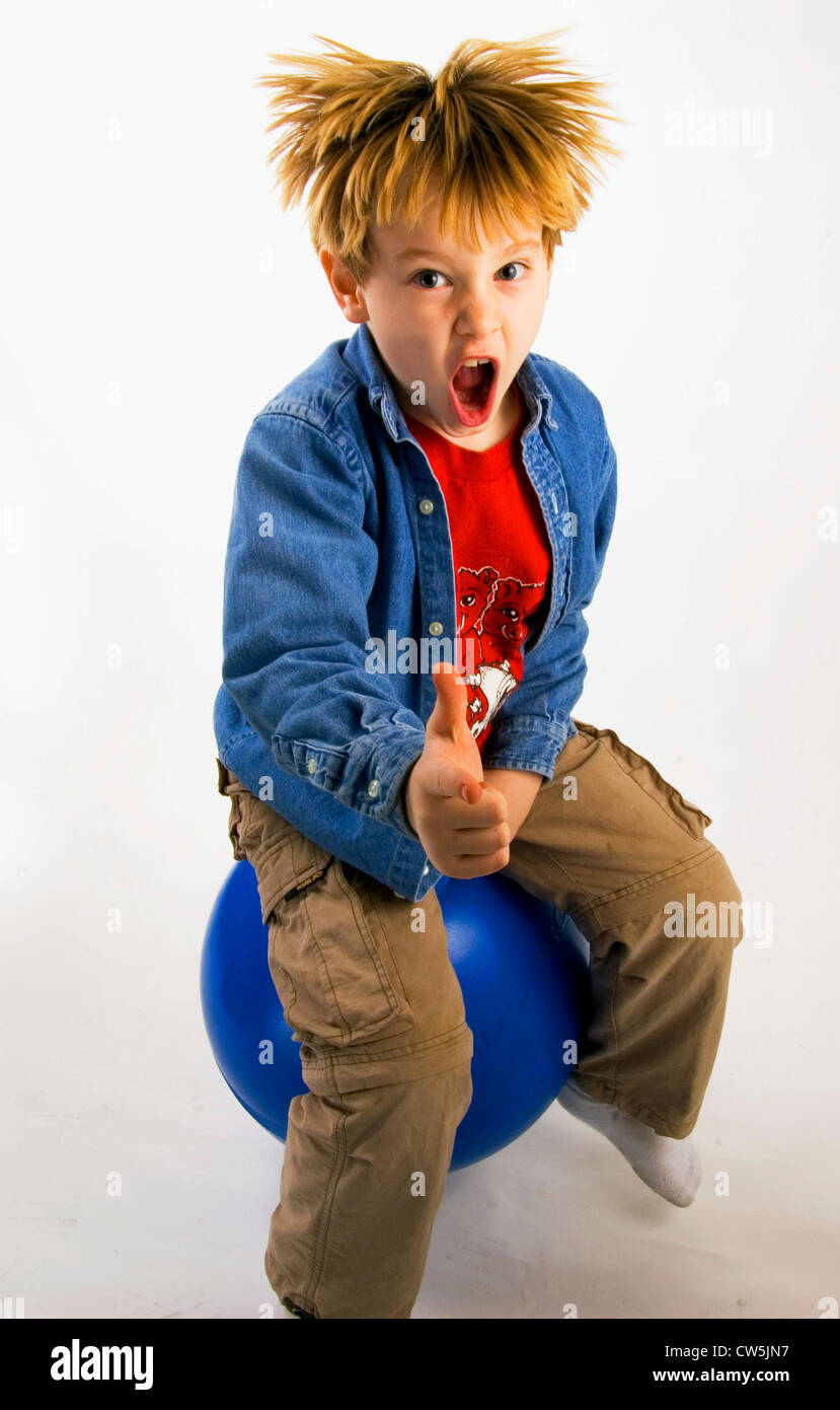Ragazzo rimbalza su una sfera di fitness Foto Stock