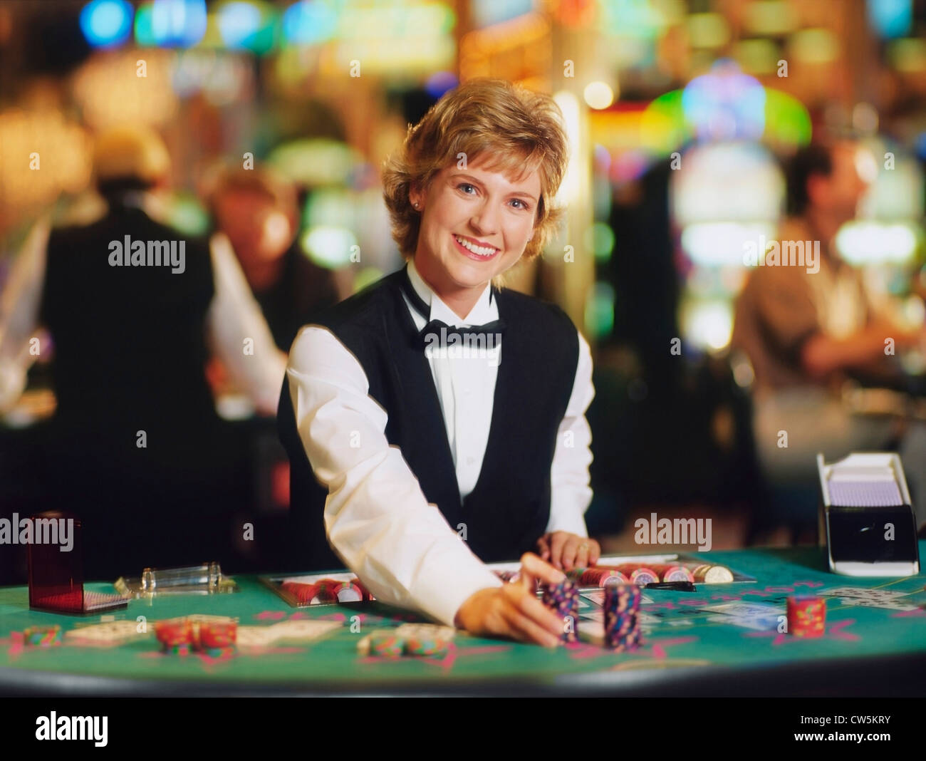 Casino femmina lavoratore ponendo fiches sul tavolo Foto Stock