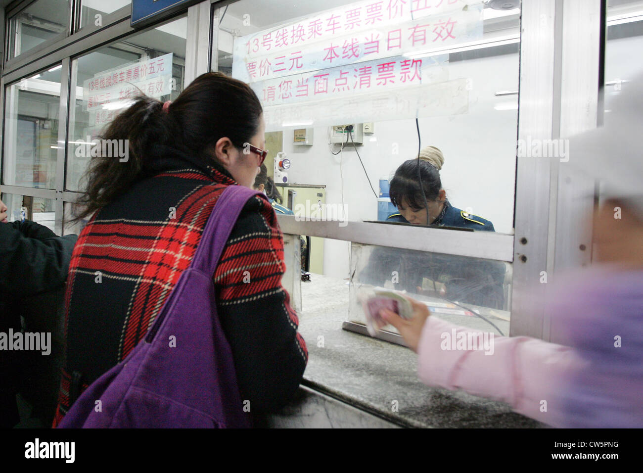 Donna di Pechino presso la biglietteria della stazione della metropolitana Foto Stock