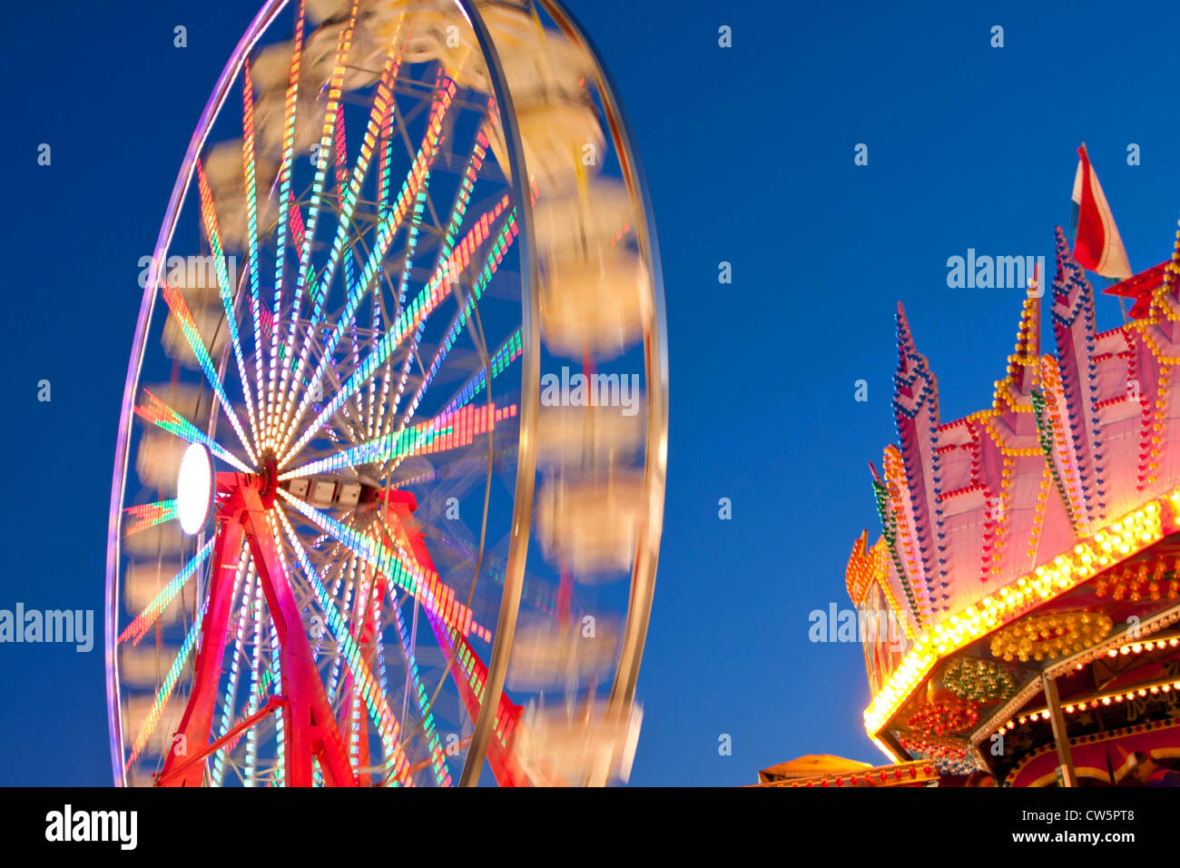 Colori luminosi di una ruota panoramica Ferris Blur contro il cielo notturno Foto Stock
