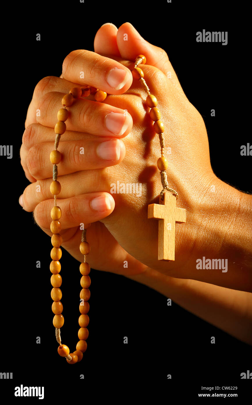 Umano cristiano pregare con il rosario in mano Foto Stock