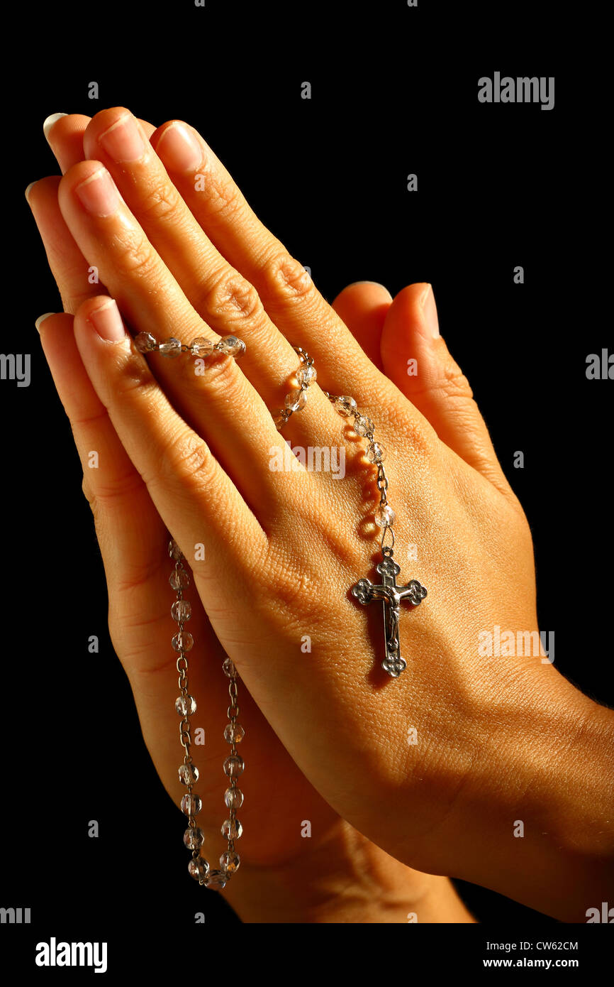 Umano cristiano pregare con il rosario in mano Foto Stock