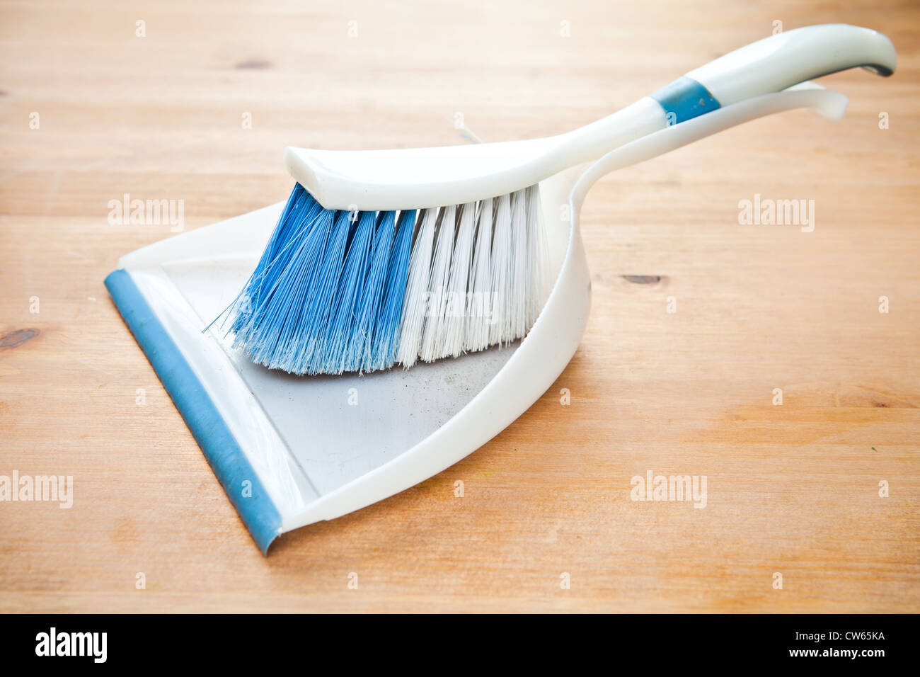 Una paletta di plastica e pennello su un pavimento di legno Foto Stock