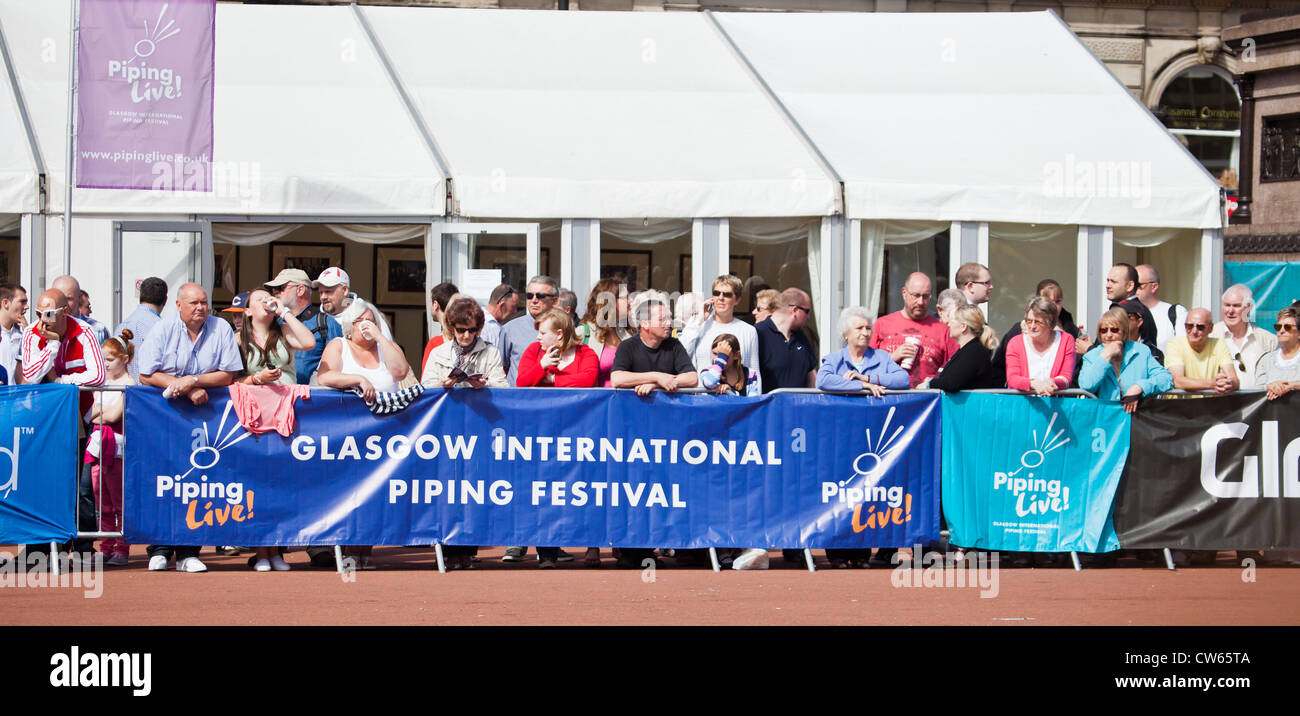 Pubblico per una performance in George Square, dietro un banner per tubazioni Live!, Glasgow internazionali del Festival di tubazioni. Foto Stock