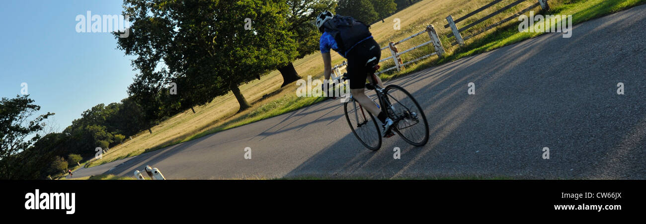Schermo widescreen panoramico colpo di ciclisti a cavallo attraverso il parco di Richmond, a sud-ovest di Londra - Inghilterra Foto Stock