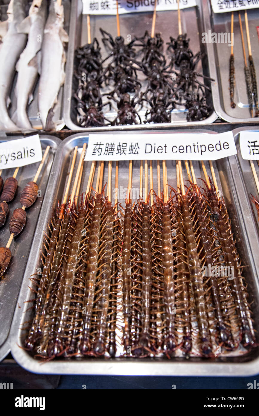 Venditore ambulante vendita di cibi esotici al night market alimentare lungo Wangfujing Street quartiere dello shopping a Pechino in Cina Foto Stock