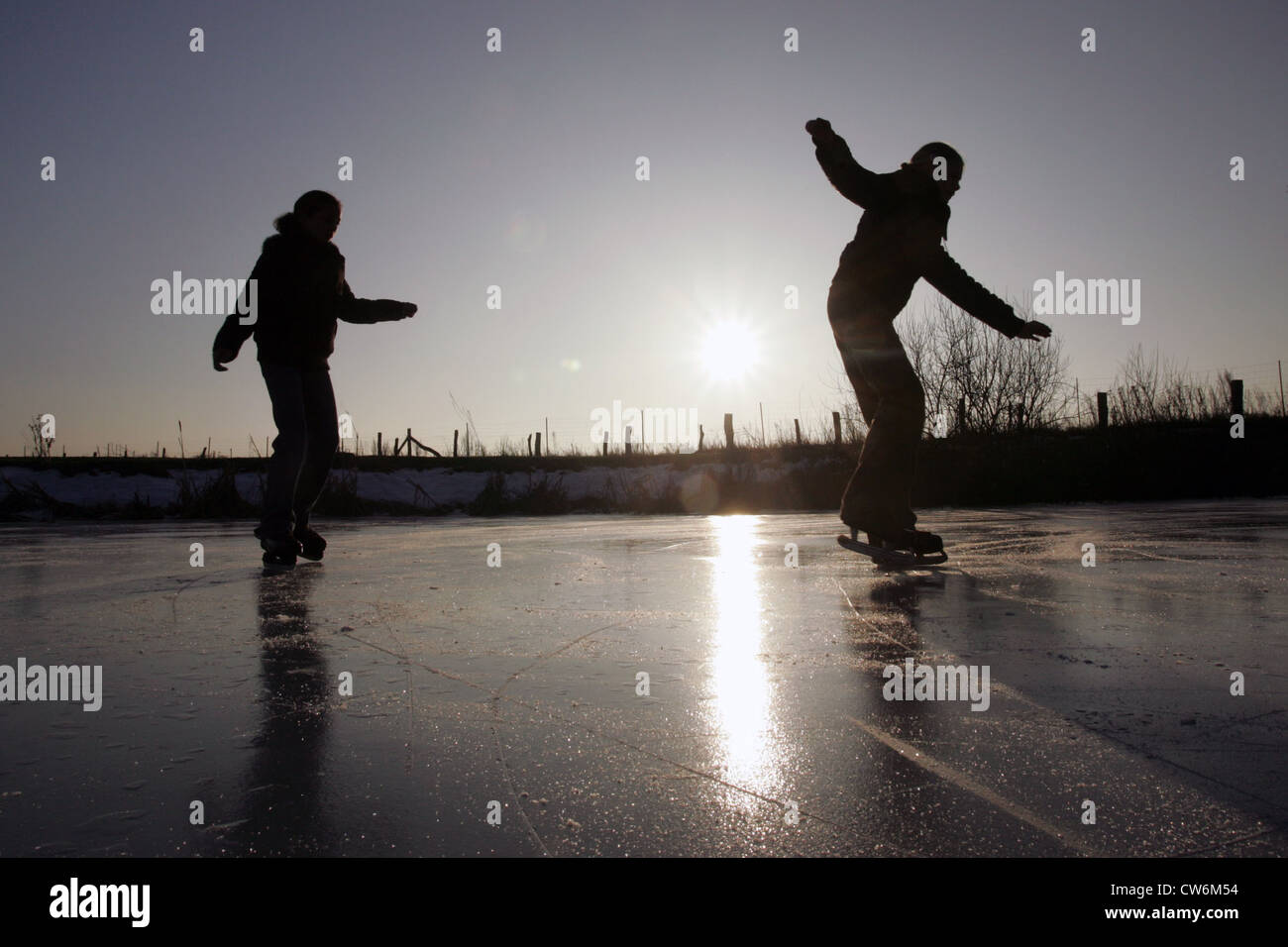 Risplendente le donne del villaggio mentre pattinaggio un lago ghiacciato Foto Stock