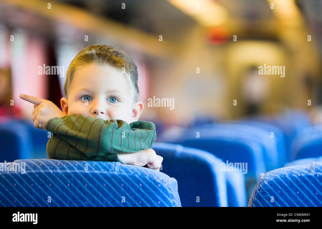 Carino a 4 anni vecchio ragazzo che viaggiano in treno Foto Stock