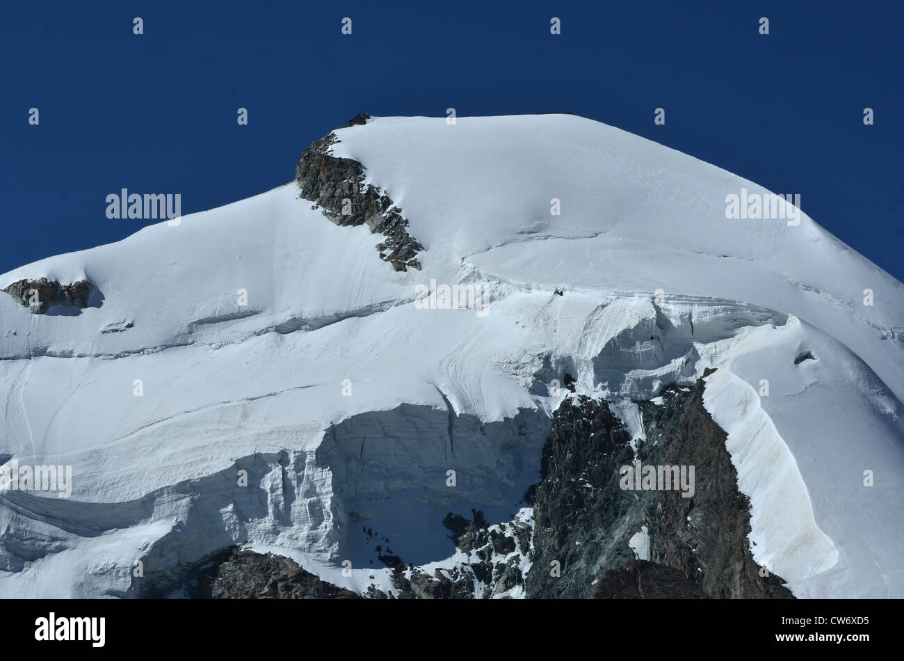 Il vertice e la parete nord del Allalinhorn nel sud delle alpi svizzere tra Zermatt e Saas Fee. Mostra un team di scalatori Foto Stock