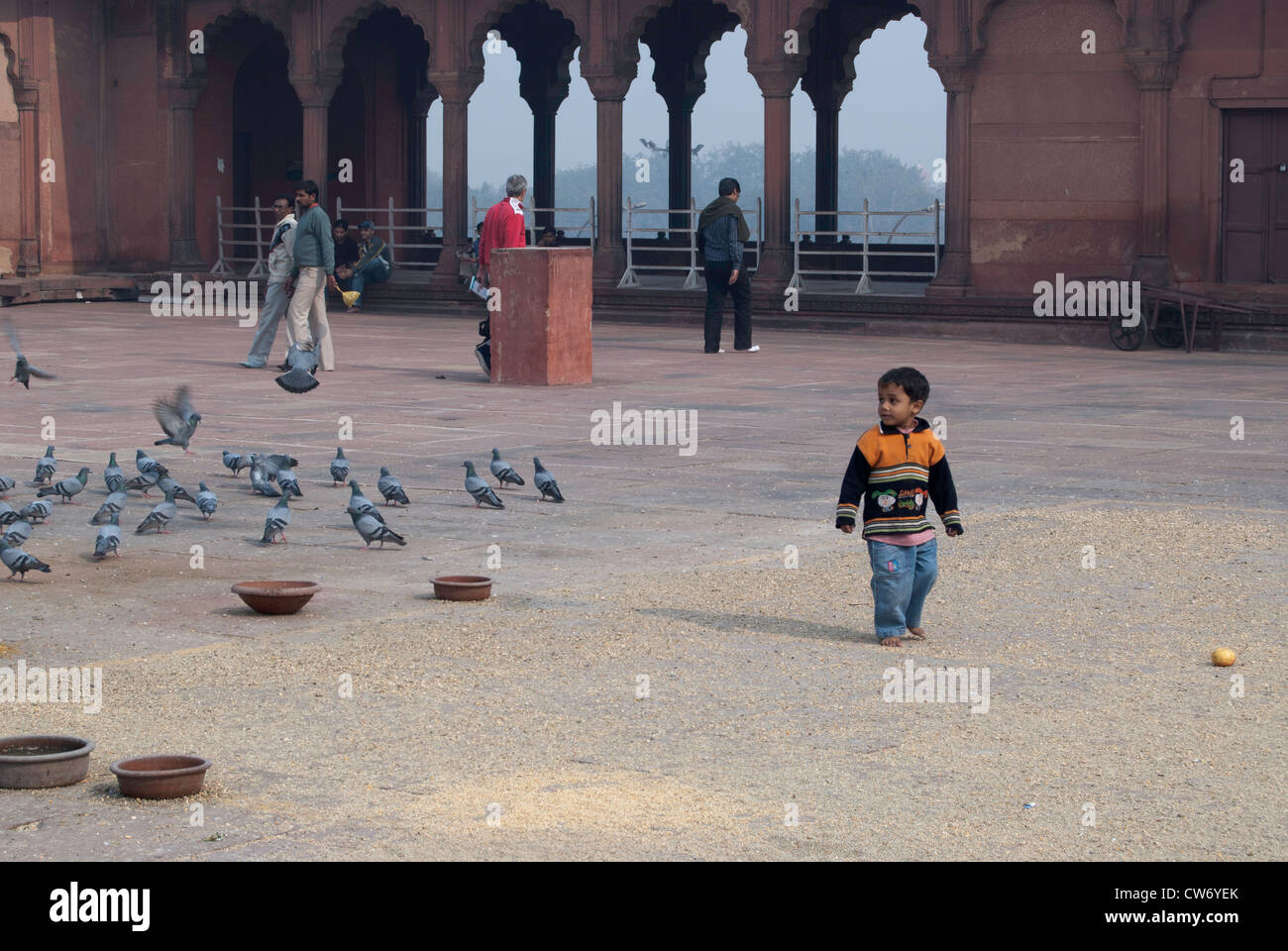 Bambino a camminare nel cortile interno la Jama Masjid di Delhi. Egli è stato di avere divertimento con i piccioni e causerebbe loro di volare. Foto Stock