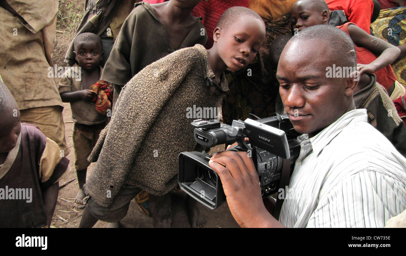 Fotocamera burundesi uomo le riprese di membri della minoranza dei Batwa, Burundi Bujumbura rurale, Mutimbuzi Foto Stock