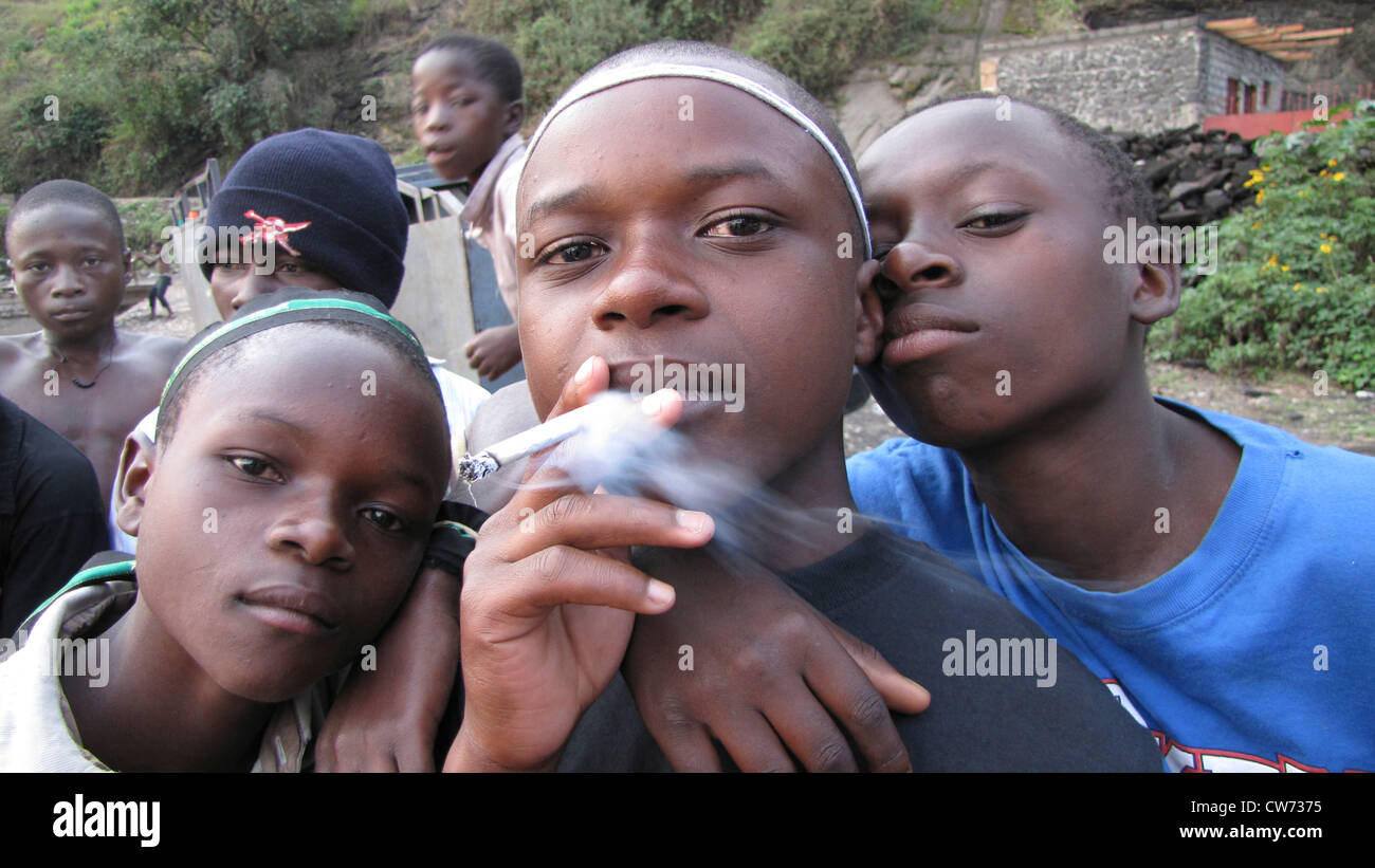 Gli adolescenti di fumare sigarette nei pressi del porto di Goma, nella Repubblica democratica del Congo, il nord Kivu, Goma Foto Stock