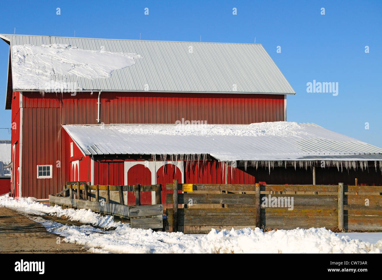 Stati Uniti Illinois scena invernale Midwestern farm stalla moderna con ghiaccioli lungo le linee del tetto Foto Stock