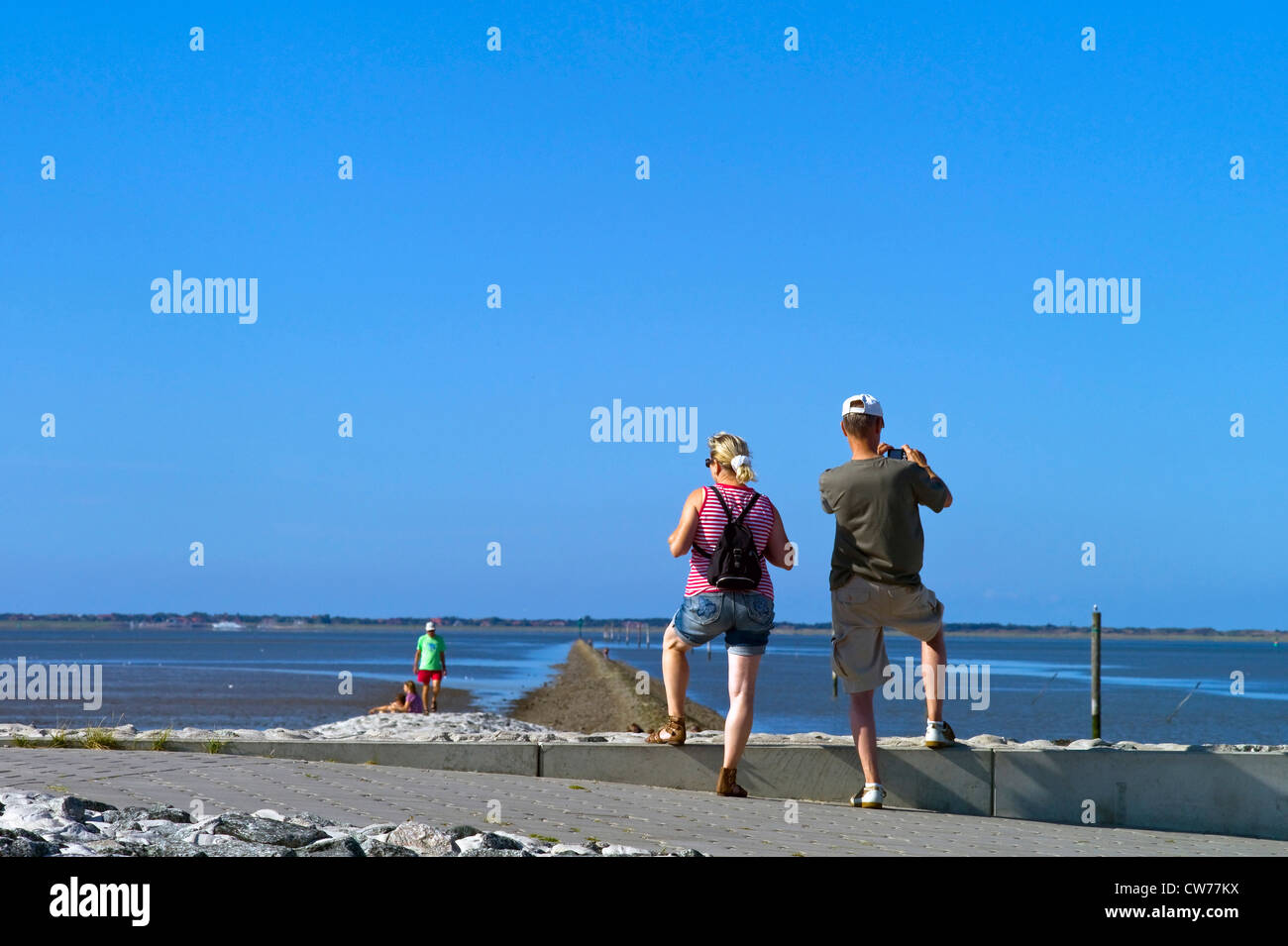 I turisti in piedi sulla mole, Germania, Bassa Sassonia, Neuharlingersiel Foto Stock